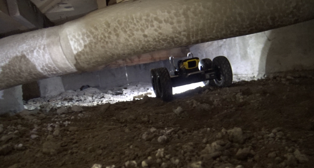 Crawl space inspection robot capturing footage beneath pier and beam home to identify foundation issues.